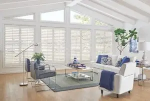 A living room with white furniture and large windows.